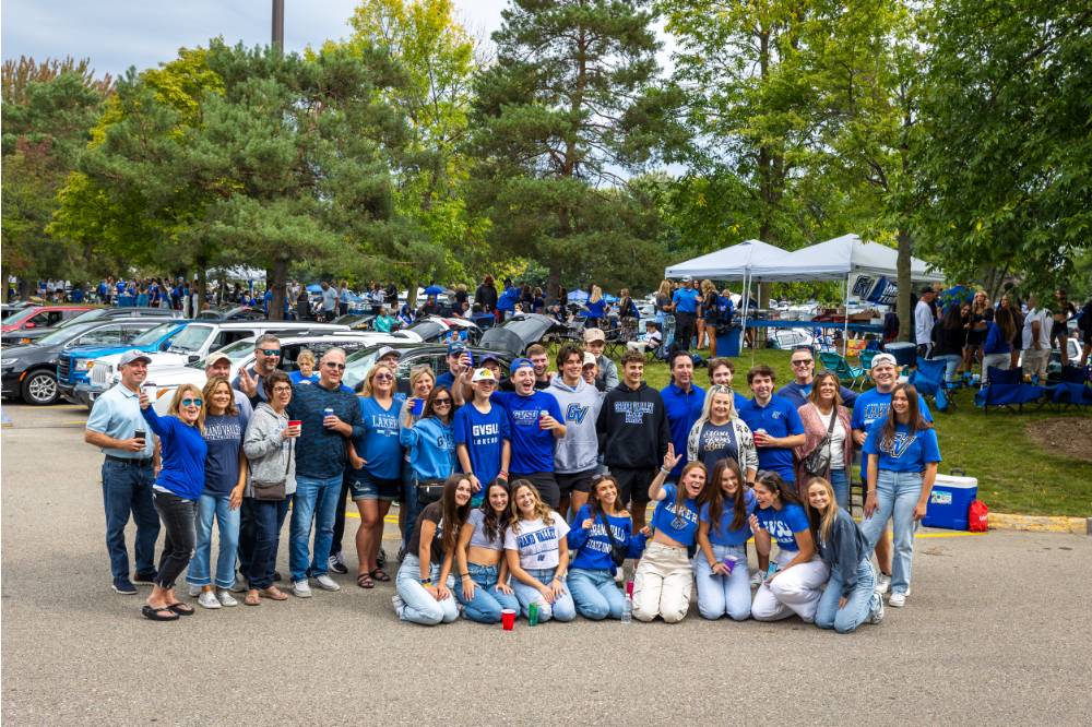 Large group of people poses for picture during Family Day tailgate.